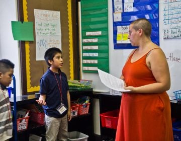 A third-grade student explains to Isy Abraham-Raveson about why he chose the green light on behavior during a consent workshop. (Kimberly Paynter/WHYY)