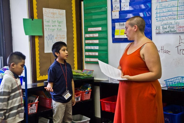 A third-grade student explains to Isy Abraham-Raveson about why he chose the green light on behavior during a consent workshop. (Kimberly Paynter/WHYY)