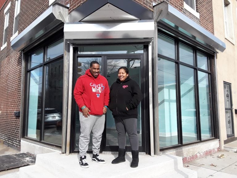 Al Harris, left, and Marjani 'MJ' Harris, right, stand outside the new CancerWho? community center in the Port Richmond neighborhood. (Trenae Nuri/WHYY News) 