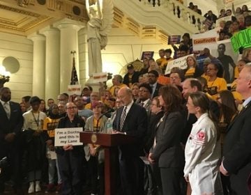 Governor Tom Wolf speaks at a rally at the state Capitol, surrounded by gun control advocates. (Katie Meyer/WITF)