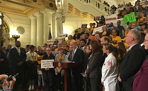 Governor Tom Wolf speaks at a rally at the state Capitol, surrounded by gun control advocates. (Katie Meyer/WITF)