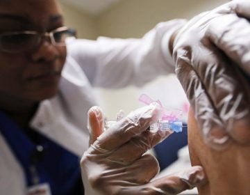 Registered Nurse Claudina Prince administers a flu shot at a Dekalb County health center in Decatur, Ga., Monday, Feb. 5, 2018.  (AP Photo/David Goldman)