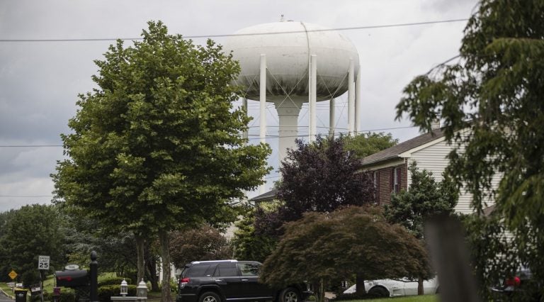 A water tower stands above a residential neighborhood