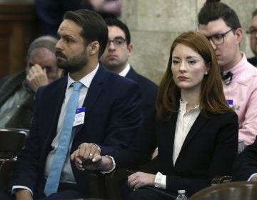 In this file photo, Katie Brennan, the chief of staff at the New Jersey Housing and Mortgage Finance Agency, holds hands with her husband Travis Miles as she waits to testify before the Select Oversight Committee at the Statehouse, Tuesday, Dec. 4, 2018, in Trenton, N.J. (Mel Evans/AP Photo)