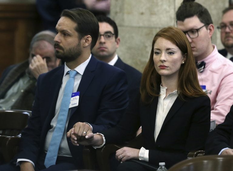 In this file photo, Katie Brennan, the chief of staff at the New Jersey Housing and Mortgage Finance Agency, holds hands with her husband Travis Miles as she waits to testify before the Select Oversight Committee at the Statehouse, Tuesday, Dec. 4, 2018, in Trenton, N.J. (Mel Evans/AP Photo)