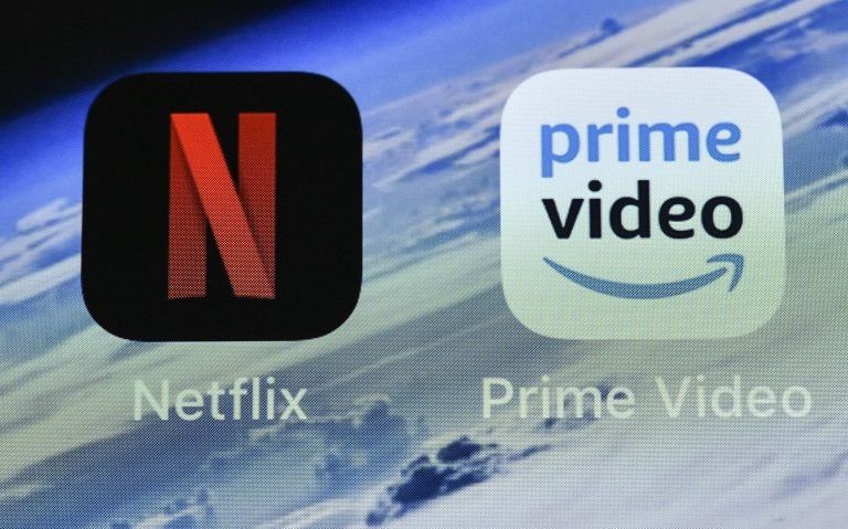 In this Thursday, Nov. 15, 2018 file photo, the icons of streaming services Netflix and AmazonPrime Video are pictured on an iPhone in Gelsenkirchen, Germany. Streaming your favorite movies and TV shows is about to get way more expensive. Amazon Prime customers can add-on subscriptions to HBO, Showtime or Starz. (Martin Meissner/AP Photo, File)