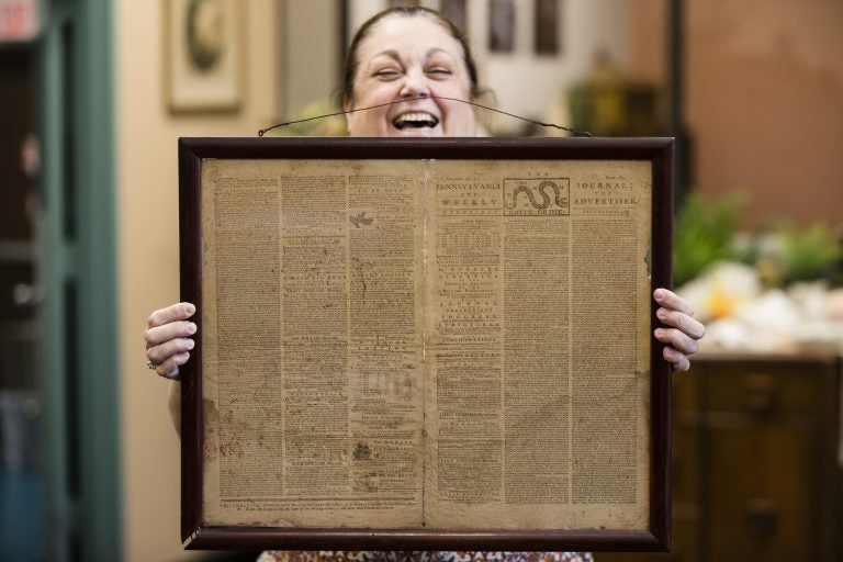 In this Thursday, Oct. 25, 2018 file photo, Heather Randall displays a Dec. 28, 1774 Pennsylvania Journal and the Weekly Advertiser at the Goodwill Industries South Jersey in Bellmawr, N.J.  An original 1774 Philadelphia newspaper that was discovered at a New Jersey Goodwill is heading to a Philadelphia philosophy society founded by Benjamin Franklin. (Matt Rourke/AP)