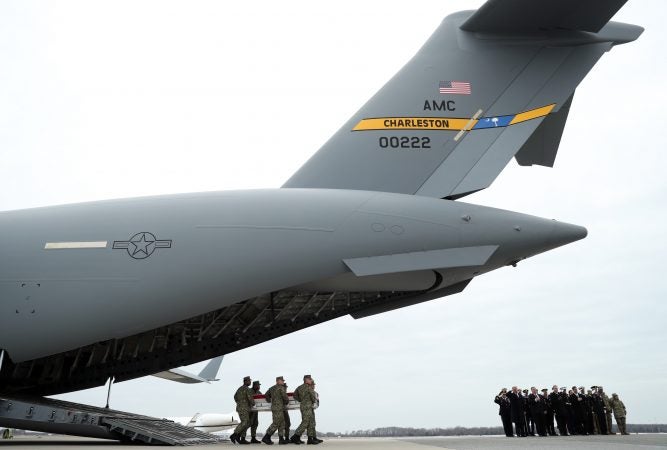 Members of the official party, including President Donald Trump and Secretary of State Mike Pompeo, right, watch, as a U.S. Navy carry team moves a transfer case containing the remains of Scott A. Wirtz, Saturday, Jan. 19, 2019, at Dover Air Force Base, Del. According to the Department of Defense, Wirtz, a civilian and former Navy SEAL from St. Louis, Mo., was killed Jan. 16, 2019, in a suicide bomb attack in Manbij, Syria. (Andrew Harnik/AP Photo)