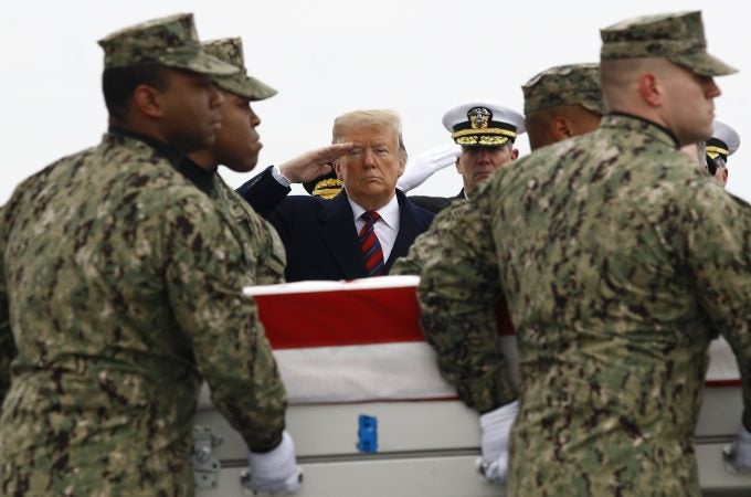 President Donald Trump salutes as a U.S. Navy carry team moves a transfer case containing the remains of Scott A. Wirtz, Saturday, Jan. 19, 2019, at Dover Air Force Base, Del. According to the Department of Defense, Wirtz, a civilian and former Navy SEAL from St. Louis, Mo., was killed Jan. 16, 2019, in a suicide bomb attack in Manbij, Syria. (Patrick Semansky/AP Photo)