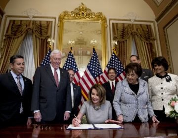 House Speaker Nancy Pelosi of Calif., center, accompanied by from left, Rep. Ben Ray Lujan, D-N.M., House Majority Leader Steny Hoyer of Md., Rep. Nita Lowey, D-N.Y, Rep. Lucille Roybal-Allard, D-Calif., and others, signs a deal to reopen the government on Capitol Hill in Washington, Friday, Jan. 25, 2019. he measure now goes to the White House for President Donald Trump to sign.  (AP Photo/Andrew Harnik)