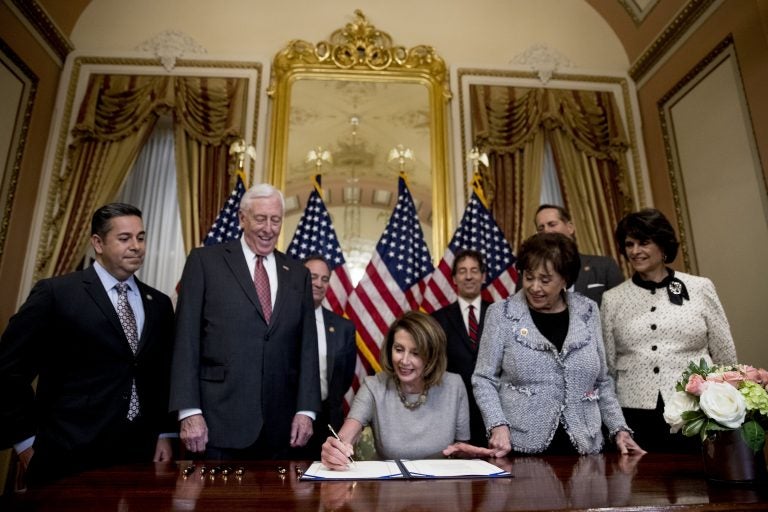 House Speaker Nancy Pelosi of Calif., center, accompanied by from left, Rep. Ben Ray Lujan, D-N.M., House Majority Leader Steny Hoyer of Md., Rep. Nita Lowey, D-N.Y, Rep. Lucille Roybal-Allard, D-Calif., and others, signs a deal to reopen the government on Capitol Hill in Washington, Friday, Jan. 25, 2019. he measure now goes to the White House for President Donald Trump to sign.  (AP Photo/Andrew Harnik)