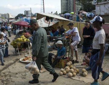 Workers and customers gather at a wholesale food market in Caracas, Venezuela, Monday, Jan. 28, 2019. Economists agree that the longer the standoff between the U.S.-backed opposition leader Juan Guaido and President Nicolas Maduro drags on, the more regular Venezuelans are likely to suffer. (AP Photo/Rodrigo Abd)