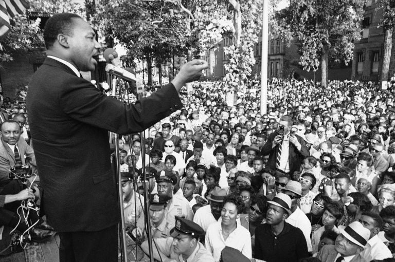 A line of police stands in front of platform from which Dr. Martin Luther King speaks during mass meeting in front of all-white Girard College in Philadelphia August 4, 1965. Dr. King said the wall surrounding the school was a symbol of evil and called for continued efforts to integrate the school.