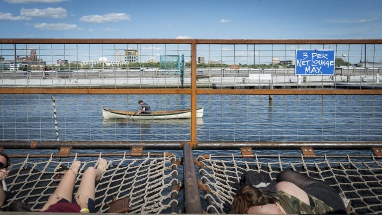 People now use the Delaware for recreation, like these visitors to Spruce Street Harbor Park. Prior to the Clean Water Act, the Delaware River was so polluted no one would have considered basking so close to it. But the regulation has not been updated for decades, and scientists say hidden dangers to fish and wildlife still exist. (Brandon Eastwood for WHYY)