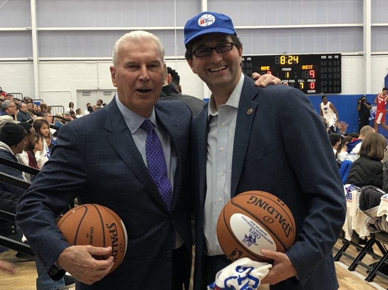 Wilmington Mayor Mike Purzycki (left) and New Castle County Executive Matt Meyer were all smiles Wednesday night at opening night for the Delaware Blue Coats at the city’s new sports and concert facility, but are locked in a dispute over the thorny and expensive issue of property tax reassessment. (Cris Barrish/WHYY)