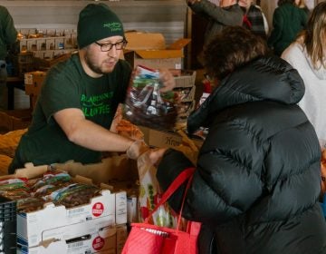 Philabundance volunteer Craig McCann hands out grapes as part of the Emergency Market for federal employees effected by the government shutdown. (Courtesy of Jonathan Gonzalez for Philabundance)