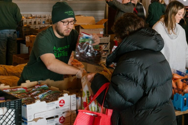 Philabundance volunteer Craig McCann hands out grapes as part of the Emergency Market for federal employees effected by the government shutdown. (Courtesy of Jonathan Gonzalez for Philabundance)