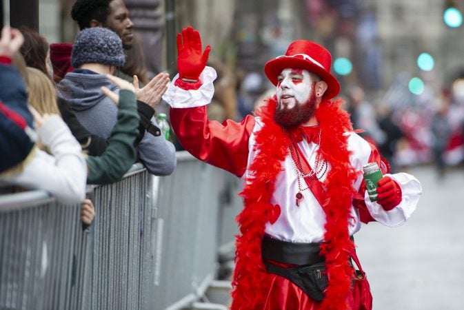 Michael Caukin a member of the Wench Division's Cara Liom high fives the spectators on Broad St.(Jonathan Wilson for WHYY)