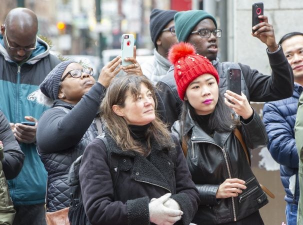 Crowds hold their phones aloft at Broad and Walnut Streets. (Jonathan Wilson for WHYY)