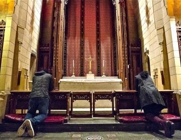 Oneita Thompson prays next to her husband, Clive, left, inside the First United Methodist Church of Germantown on Monday, Nov. 12, 2018. The couple is from Jamaica and has lived in the United States since 2004. They moved from their home in Cedarville, New Jersey, into the church last year, bringing their two youngest children, Christine, 16, and Timothy, 12, with them. (Heather Khalifa/The Philadelphia Inquirer)