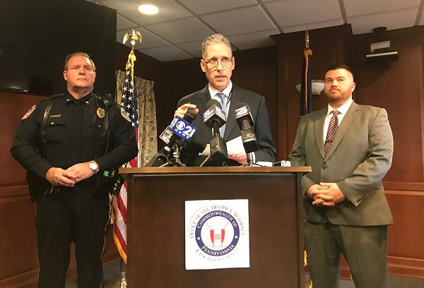 Lancaster County District Attorney Craig Stedman, center, speaks to reporters Dec. 6, 2018 about the October 26 multi-vehicle crash that killed two Warwick High School students. At left is Lititz Borough Police Chief Kerry Nye. At right, Lancaster County Assistant District Attorney Jared Hinsey. (Brett Sholtis/WITF News)