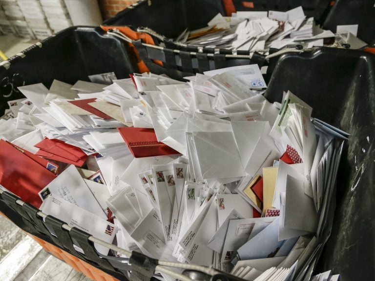 Letters wait in bins for sorting at the main post office in Omaha, Neb. The price of a Forever stamp has increased by 10 percent as the U.S. Postal Service contends with billions of dollars in annual losses. (Nati Harnik/AP)