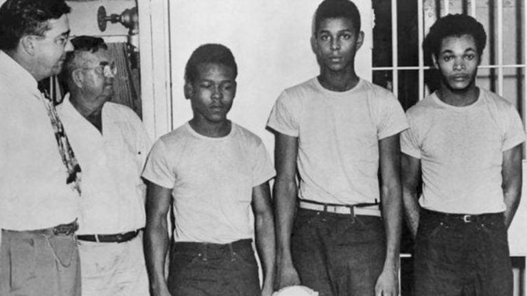 (From left) Lake County, Fla., Sheriff Willis McCall and an unidentified man stand next to Walter Irvin, Samuel Shepherd and Charles Greenlee. The three were accused of rape in 1949, along with a fourth man. They were all pardoned Friday. (State Library and Archives of Florida via AP)