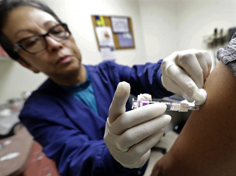 Ana Martinez gives a patient a flu shot