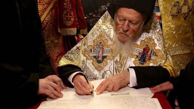 Bartholomew I signs the Tomos of Autocephaly, marking the formal independence of the Ukrainian Orthodox Church at the Patriarchal Church of St. George, in Istanbul.
(Anadolu Agency/Getty Images)