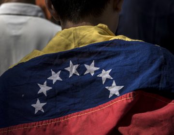 An attendee wears a Venezuelan flag during a rally in Caracas Friday with Juan Guaido, president of the National Assembly, who swore himself in as the leader of Venezuela. (Marcelo Perez del Carpio/Bloomberg via Getty Images)