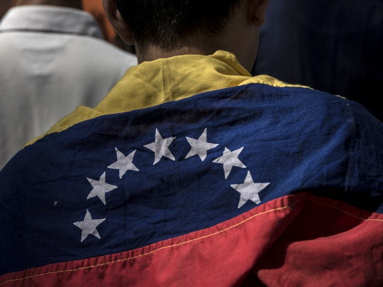 An attendee wears a Venezuelan flag during a rally in Caracas Friday with Juan Guaido, president of the National Assembly, who swore himself in as the leader of Venezuela. (Marcelo Perez del Carpio/Bloomberg via Getty Images)