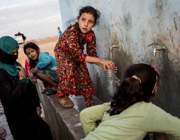 Access to water is increasingly entangled with conflict situations. (Above) A young girl fills a bottle at a pump station at a camp for internally displaced people in Ain Issa, Syria.
(Chris McGrath/Getty Images)
