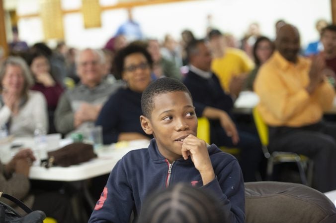 Maurice Barnes watches a video in which he is featured at Uneven Play: A Community Dinner and Conversation. (Jonathan Wilson for WHYY)