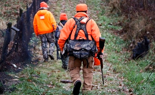 Santo Cerminaro, (right), follows his son, Dominick Cerminaro, (left), and grandson, Santo Cerminaro, 11, into the woods to go deer hunting on the first day of regular firearms deer hunting season, in most of Pennsylvania, Monday, Nov. 26, 2018 in Zelienople, Pa. (Keith Srakocic/AP Photo)