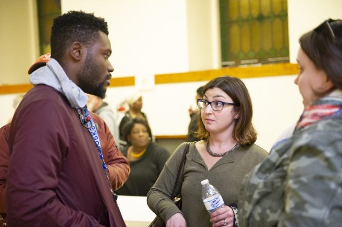 Members of non-profit Playworks, (from left) Dontae Privette, Ivy Olesh, and Corrie O'Neil, talk after Uneven Play: A Community Dinner and Conversation. (Jonathan Wilson for WHYY)