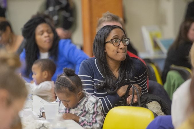 Members of the audience listen to speakers while their children draw pictures during Uneven Play: A Community Dinner and Conversation. (Jonathan Wilson for WHYY)