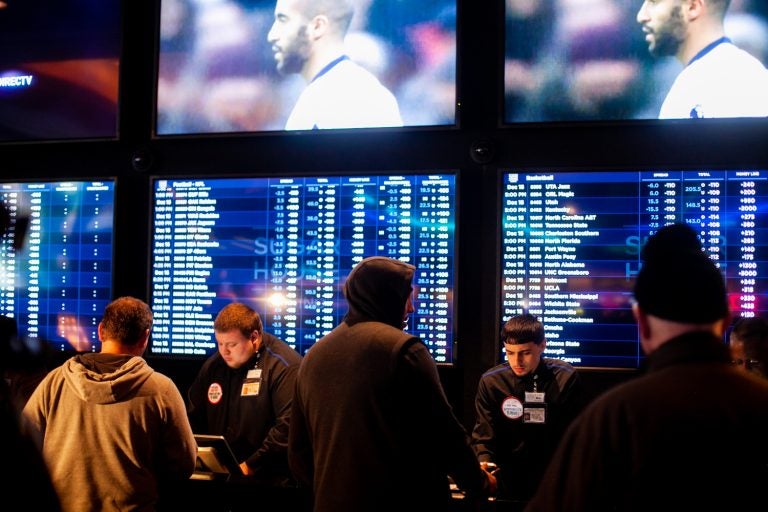 Prospective bettors place their wagers on sports events at the Sugar House Casino. (Brad Larrison for WHYY)