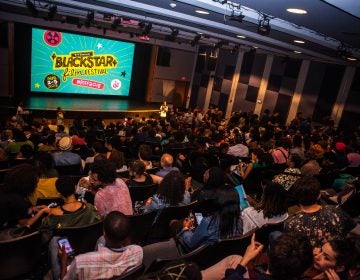 Audience members look towards a screen that says 