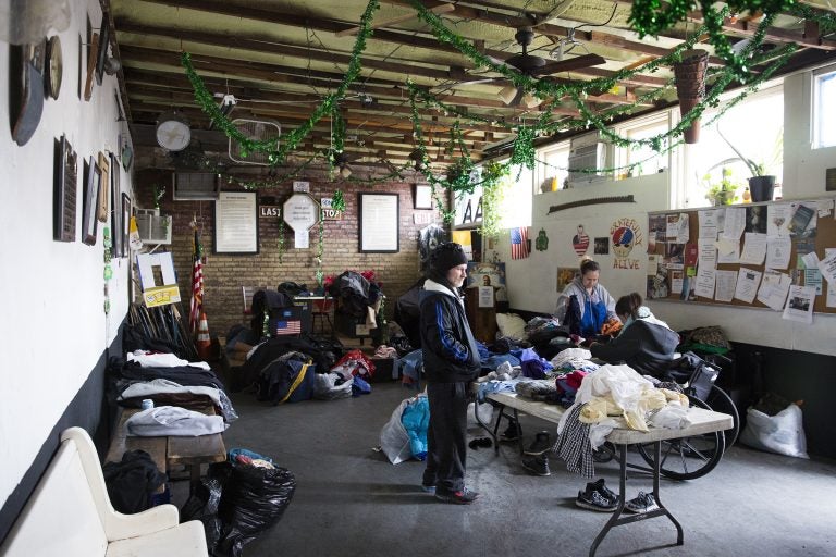 Lou (left) and Michelle (center) organize donated clothes so that community members can more easily pick through them on Feb. 17. The Last Stop is a recovery clubhouse that gives donated clothes to the community each weekend. (Rachel Wisniewski for WHYY)