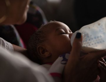 Theresa Reid feeds her five-month-old niece, Ummayyah, a bottle of breast milk that was pumped by Ummayyah's mother, Cierra Jackson, who is serving a 6-to-23-month sentence at Riverside Correctional Facility, in Philadelphia. (Kriston Jae Bethel/Next City)
