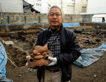 Archaeologist Koji Iesaki holds a carved roof ornament excavated at the former site of the Jyokyo-ji temple in Kyoto. Iesaki and other archaeologists have their hands full, as a pre-Olympic building boom has helped reveal centuries-old artifacts from the city's long history. (Anthony Kuhn/NPR)