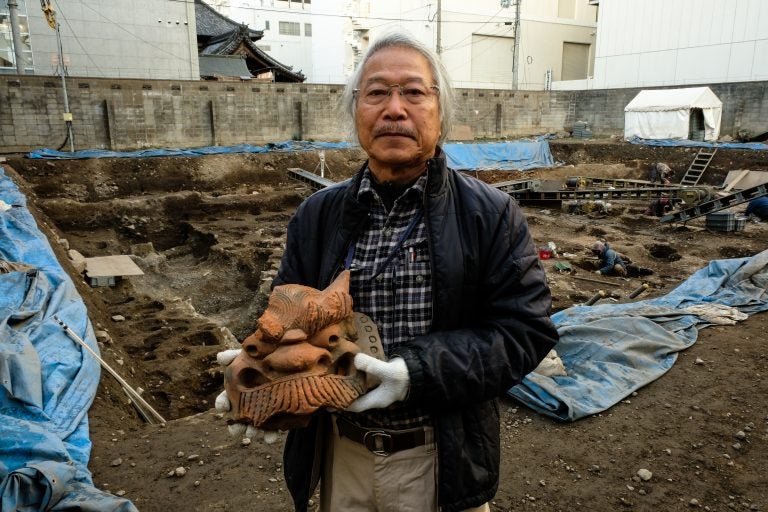 Archaeologist Koji Iesaki holds a carved roof ornament excavated at the former site of the Jyokyo-ji temple in Kyoto. Iesaki and other archaeologists have their hands full, as a pre-Olympic building boom has helped reveal centuries-old artifacts from the city's long history. (Anthony Kuhn/NPR)