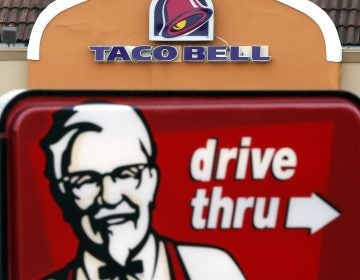 This Jan. 31, 2014, file photo, shows a Taco Bell facade behind a KFC drive-thru sign (Elise Amendola/AP Photo, File)