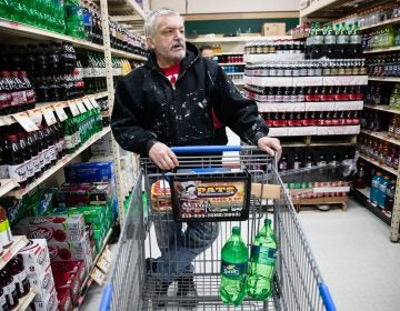 In this March 16, 2017 photo, customer Fran Flanagan is interviewed as he shops for soda at the IGA supermarket in the Port Richmond neighborhood of Philadelphia. The city's tax on sweetened drinks remains controversial two years later. (AP Photo/Matt Rourke)