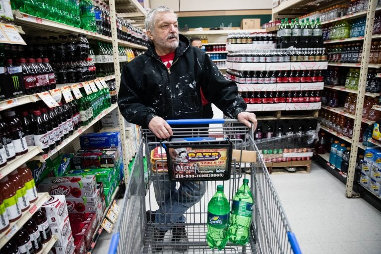 In this March 16, 2017 photo, customer Fran Flanagan is interviewed as he shops for soda at the IGA supermarket in the Port Richmond neighborhood of Philadelphia. The city's tax on sweetened drinks remains controversial two years later. (AP Photo/Matt Rourke)