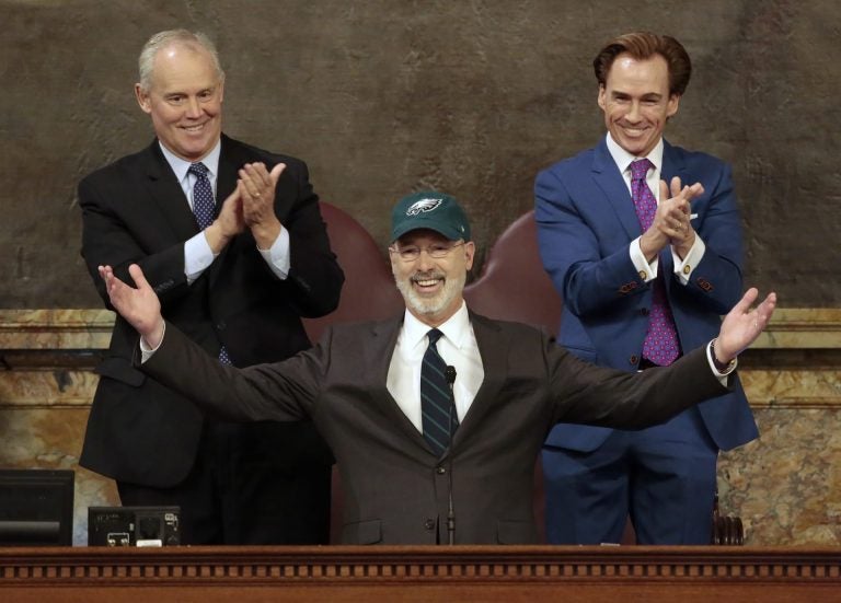 Democratic Gov. Tom Wolf puts on a Philadelphia Eagles hat to celebrate their Super Bowl win before he gives his budget address at the state Capitol in Harrisburg, Pa., on Tuesday, Feb. 6, 2018. (AP Photo/Chris Knight)