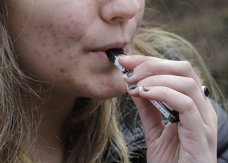 In this April 11, 2018 file photo, a high school student uses a vaping device near a school campus in Cambridge, Mass. (Steven Senne/AP Photo)