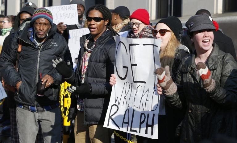 Demonstrators hold signs and chant outside the Governors office at the Capitol in Richmond, Va., Saturday, Feb. 2, 2019. The demonstrators are calling for the resignation of Virginia Governor Ralph Northam after a 30 year old photo of him on his medical school yearbook photo was widely distributed Friday. (Steve Helber/AP Photo)