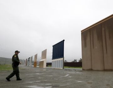 Border Patrol agent Vincent Pirro walks towards prototypes for a border wall Tuesday, Feb. 5, 2019, in San Diego. President Donald Trump is expected to speak about funding for a wall along the U.S.-Mexico border during his State of the Union address Tuesday. (Gregory Bull/AP Photo)