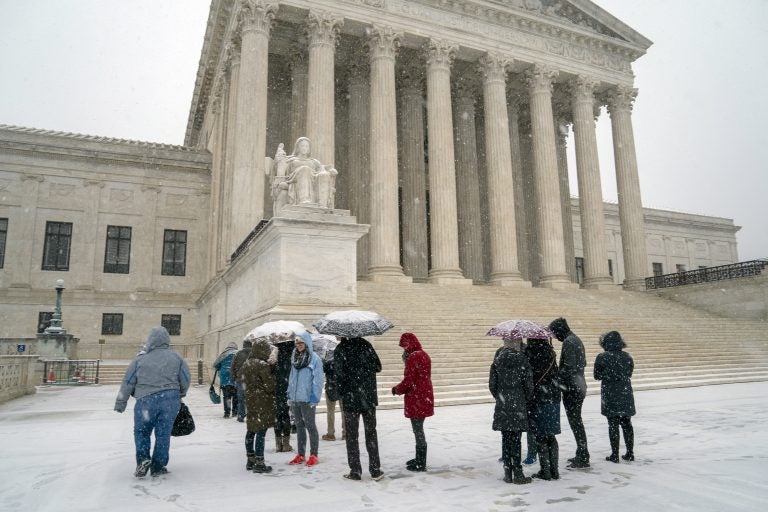 Visitors wait to enter the Supreme Court as a winter snow storm hits the nation's capital making roads perilous and closing most Federal offices and all major public school districts, on Capitol Hill in Washington, Wednesday, Feb. 20, 2019. The Supreme Court is ruling unanimously that the Constitution's ban on excessive fines applies to the states. (J. Scott Applewhite/AP Photo)